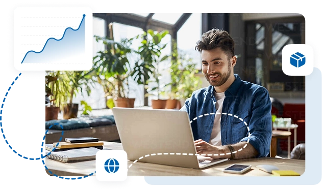 Man working on a laptop in a bright office with plants